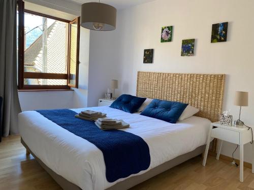LalleyAuberge du Grand Champ的一间卧室配有一张带蓝色枕头的大床