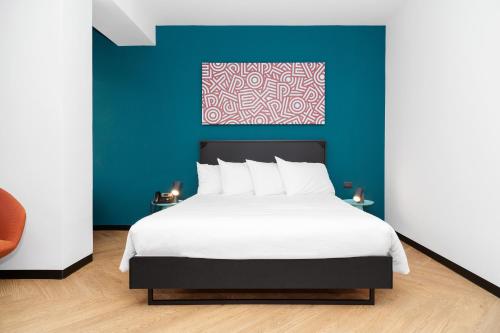 都灵CX Turin Belfiore Student&Explorer Place的一间卧室设有一张蓝色墙壁的大床