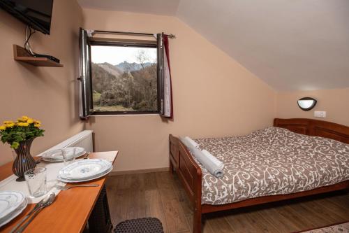 Crni VrhVila Nada的一间卧室配有一张床、一张桌子和一个窗户。