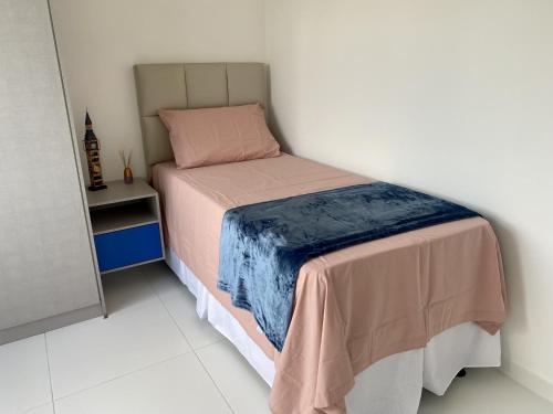 维多利亚-达孔基斯塔Dona Olivia Residencial的小卧室配有一张带毯子的床