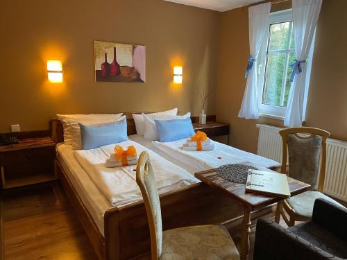 马林贝格德尔布鲁德霍赫贝格酒店的一间卧室配有一张大床、一张桌子和一张桌子。