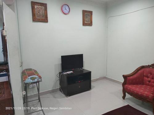 波德申Teratak Port Dickson Homestay Mus Only的一间带电视和红色沙发的客厅