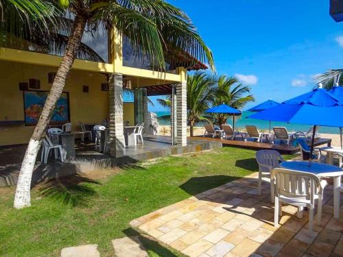 嘎林海斯港Pousada Santo Aleixo的配有桌椅和蓝伞的度假村