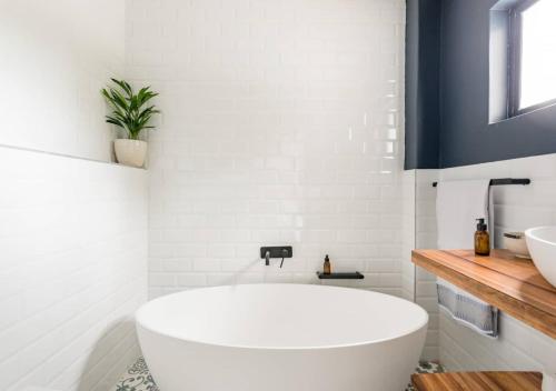 普利登堡湾Plett Holiday Stay with Pizza Oven and Views的白色的浴室设有浴缸和水槽。