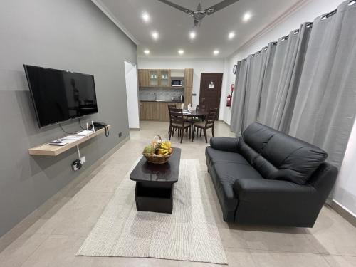 博瓦隆B Holiday Apartments的客厅配有黑色真皮沙发和桌子