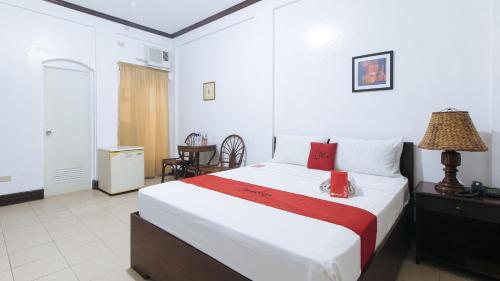 安吉利斯RedDoorz @ Marifa Hotel Angeles Pampanga的酒店客房配有一张床铺和一张桌子。