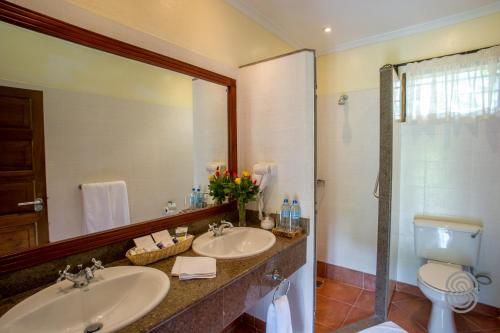NkoanruaArusha Serena Hotel的浴室设有2个水槽、卫生间和镜子。