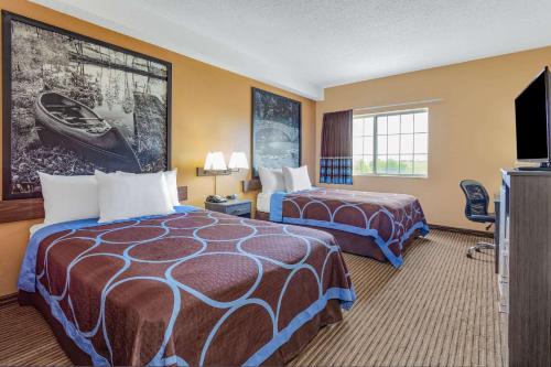 道奇堡Super 8 by Wyndham Fort Dodge IA的酒店客房设有两张床和一台平面电视。