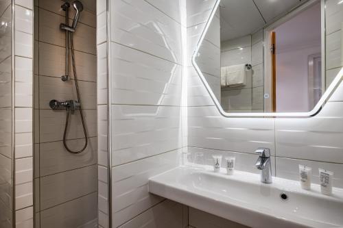 巴黎马雷娜酒店的白色的浴室设有水槽和镜子