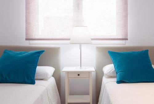 大加那利岛拉斯帕尔马斯Hercot Canteras Beach,Sun,City WIFI free的一间卧室配有两张带蓝色枕头和灯的床。