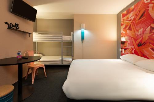 图卢兹Ibis Styles Toulouse Centre Canal du Midi的客房设有床、桌子和双层床。