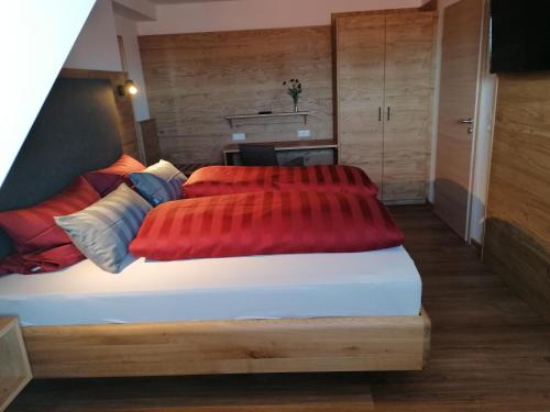LangerringenPension zum Bären的一间卧室配有一张带两个红色枕头的床