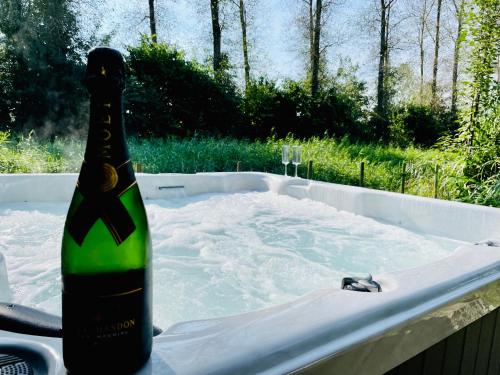 泽沃德VILLA CALMA Rust Ruimte Luxe inclusief private jacuzzi的浴缸内的一瓶香槟