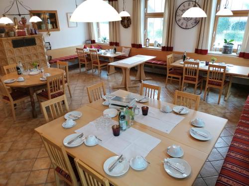 LangerringenPension zum Bären的用餐室配有木桌和椅子