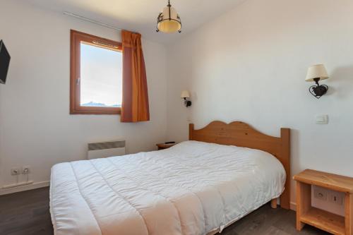 勒克比尔Les Alpages du Corbier A003的卧室配有白色的床和窗户。