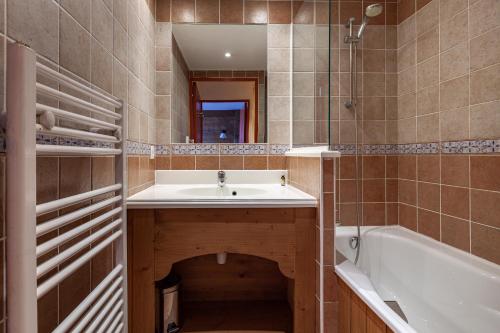 勒克比尔Les Alpages du Corbier A003的浴室配有盥洗盆和浴缸。
