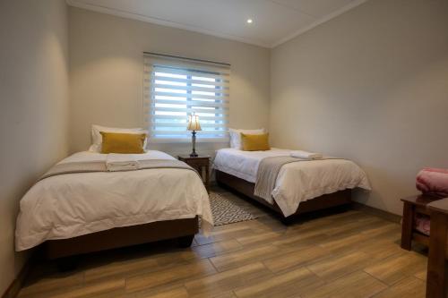 阿多Waggi Mountain Escape的一间卧室设有两张床和窗户。