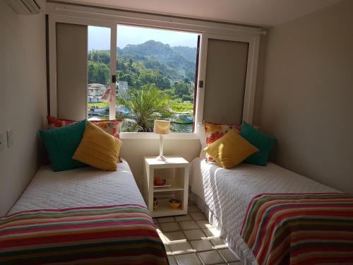 安格拉杜斯雷斯Casa no Condomínio Porto Frade - pertinho da praia的两张床位于带窗户的房间内
