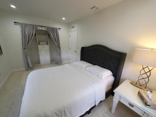 迈阿密Miami-Airport Oasis VIP House的卧室配有一张白色的大床和一张桌子