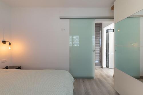 马斯帕洛马斯Tropical Lodge的一间卧室设有一张床和玻璃墙