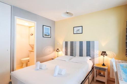 拉罗谢尔Appartement Passereaux - Welkeys的一间卧室配有一张带白色床单的大床
