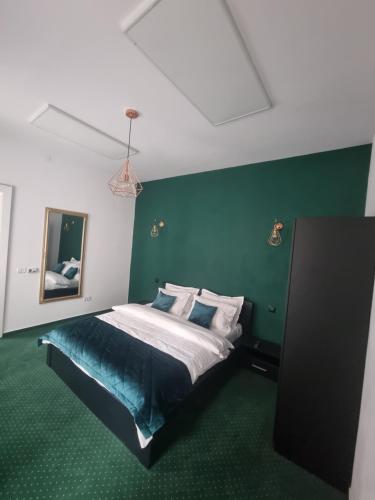 布拉索夫Celebrity Apartment Brasov的一间卧室配有一张带绿色墙壁的床