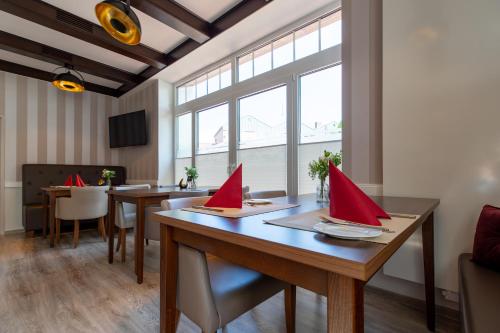SteyerbergHotel Steyerberger Hof的木桌上的用餐室,配有红色餐巾