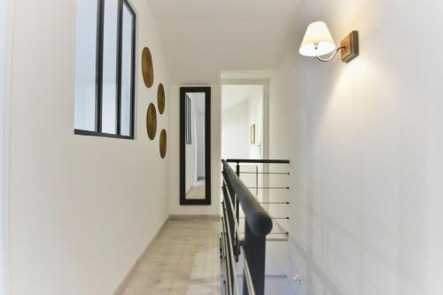 贡比涅Campagne en ville!的拥有白色墙壁的走廊和带镜子的楼梯
