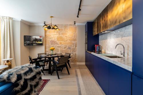 因弗内斯Pamper yourself in our DOUBLE SIZED copper tub -2 bedroom villa的厨房以及带蓝色橱柜和桌子的用餐室。