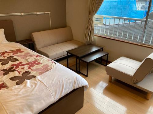 大石Koya TRIBE - Vacation STAY 83403v的一间带一张床和一把椅子的卧室以及一个阳台