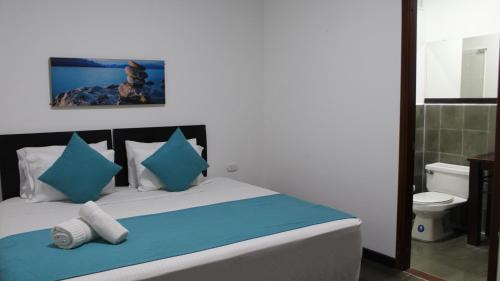 圣罗莎德卡瓦尔Hotel Los Cristales的一间卧室配有一张带蓝色和白色枕头的床
