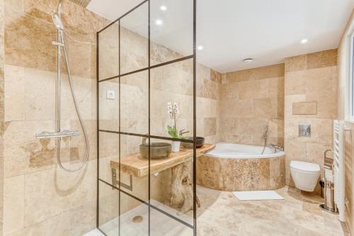 Gignac-la-NertheDOMAINE DE LA NERTHE- HOTEL PROVENCE MEDITERRANEE的带淋浴、浴缸和卫生间的浴室