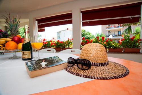 苏科尚丰塔纳别墅公寓的帽子和书,桌子上还有一瓶葡萄酒