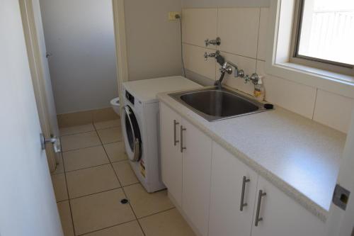 Port Noarlunga克里斯蒂斯海马假日联排别墅的一个带水槽和洗衣机的小厨房
