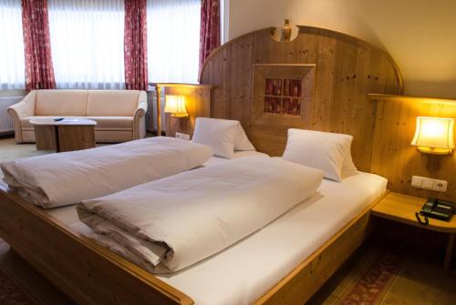 海利根布卢特Alpin Panoramahotel Lärchenhof的配有木床头板的客房内的两张床