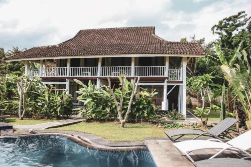 圣吉吉Anggrek Putih Homestay & Cooking Class的房屋前有游泳池的房子