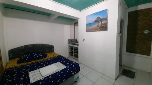 CitepusVilla Family Pantai Citepus Pelabuhanratu的一间小卧室,配有一张床和墙上的绘画