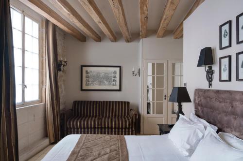 巴黎圣路易斯马莱酒店的一间卧室配有一张床和一张沙发