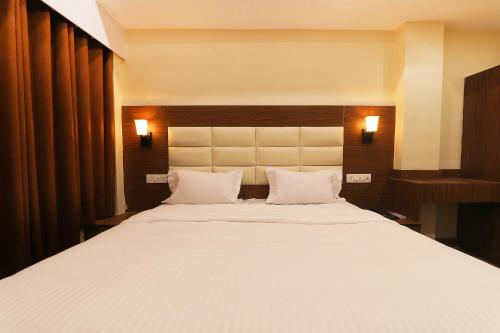 勒克瑙FabHotel Blueark的卧室配有一张带两个枕头的大白色床
