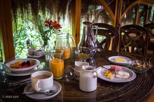 巴尼奥斯Finca Chamanapamba Guest House的一张木桌,上面摆放着早餐食品和饮料