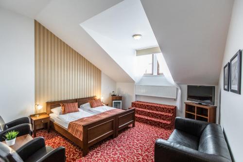 克罗梅日什Hotel U Zlatého kohouta的一间卧室配有一张床和两把椅子