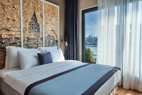 伊斯坦布尔The Halich Hotel Istanbul Karakoy - Special Category的一间卧室设有一张大床和一个窗户。