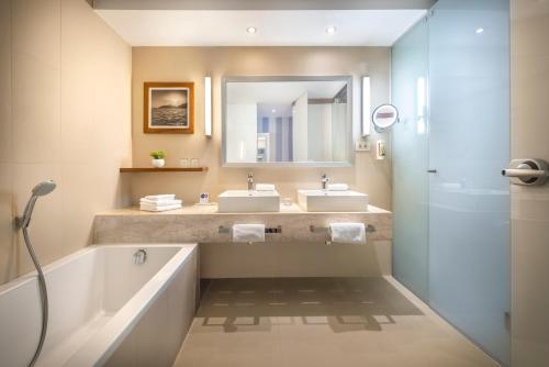 杜布罗夫尼克Dubrovnik President Valamar Collection Hotel的浴室设有2个水槽、浴缸和镜子