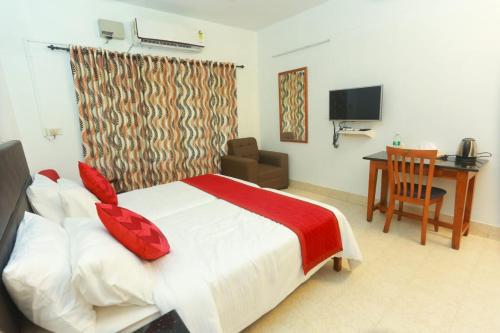 KondottiKTDC Tamarind的一间卧室配有一张床、一张书桌和一台电视