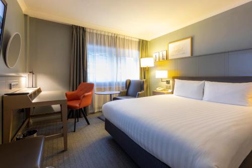 伦敦伦敦假日宾馆 - 摄政公园的酒店客房设有一张大床和一张书桌。