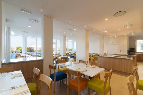 索托马里纳梅迪特拉内奥酒店的一间带桌椅的餐厅和一间自助餐厅