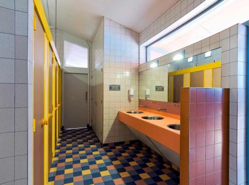阿姆斯特丹Camping Zeeburg Amsterdam的一间设有两个盥洗盆和窗户的公共浴室