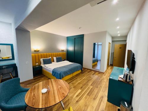 巴库CH Hotel的酒店客房配有一张床铺和一张桌子。