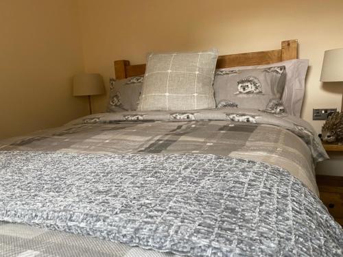 斯塔福德Ye Old Tack Room的一张带蓝色和灰色毯子和枕头的床