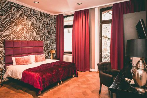 威斯巴登Hotel Villa Klemm - Wiesbaden City的一间卧室配有床、红色窗帘和窗户
